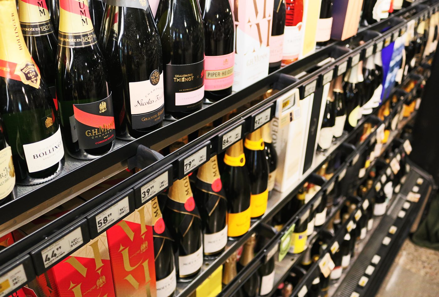Close up of champagne on shelves, each shelf edge fitted with a black Aerofoil blade carrying electronic price labels