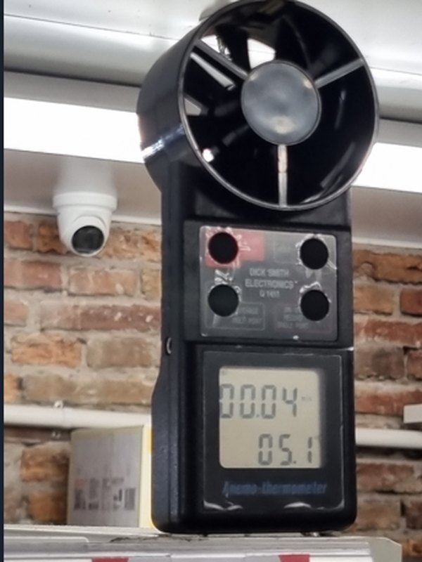 An anemometer held up at shelf height reading 0.04 metres a second and 5.1 degrees