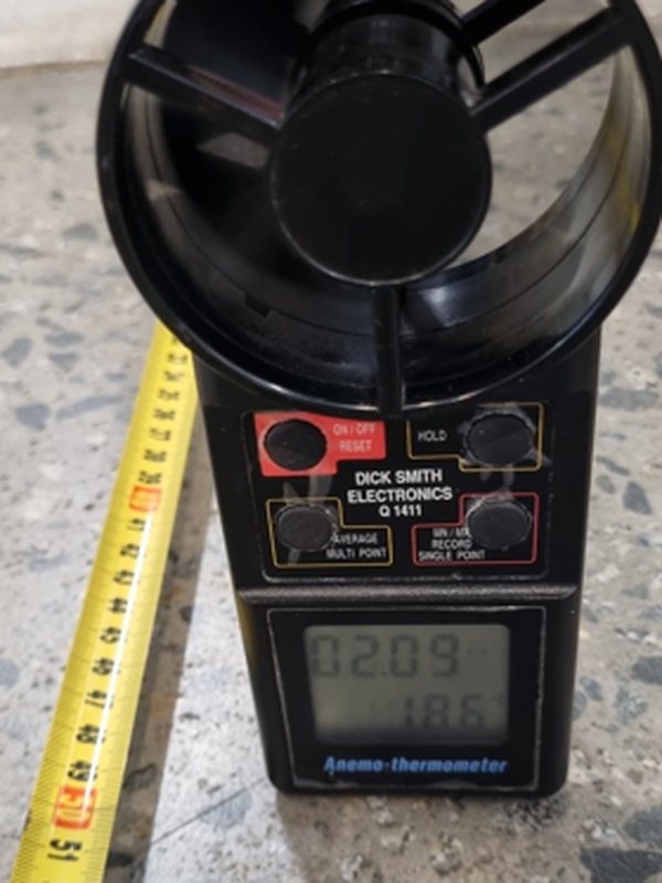 An anemometer on a speckled floor reading 2.09 metres a second and 18.6 degrees