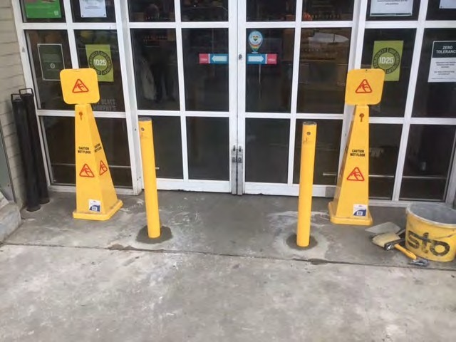 Two bollards either side of a pair of entry doors