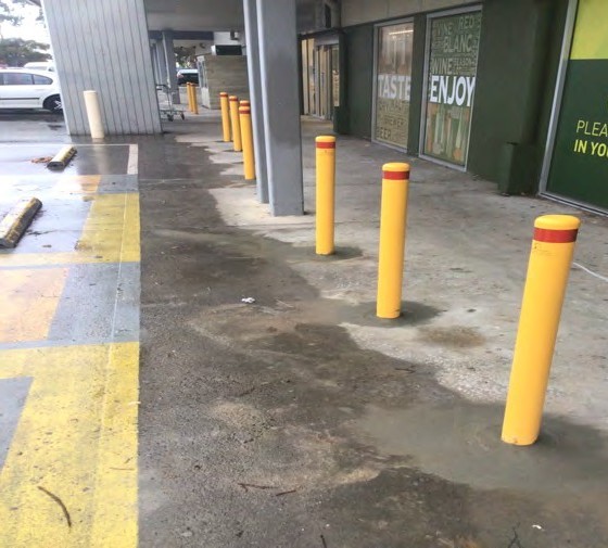 Yellow bollards along a row of pickup windows