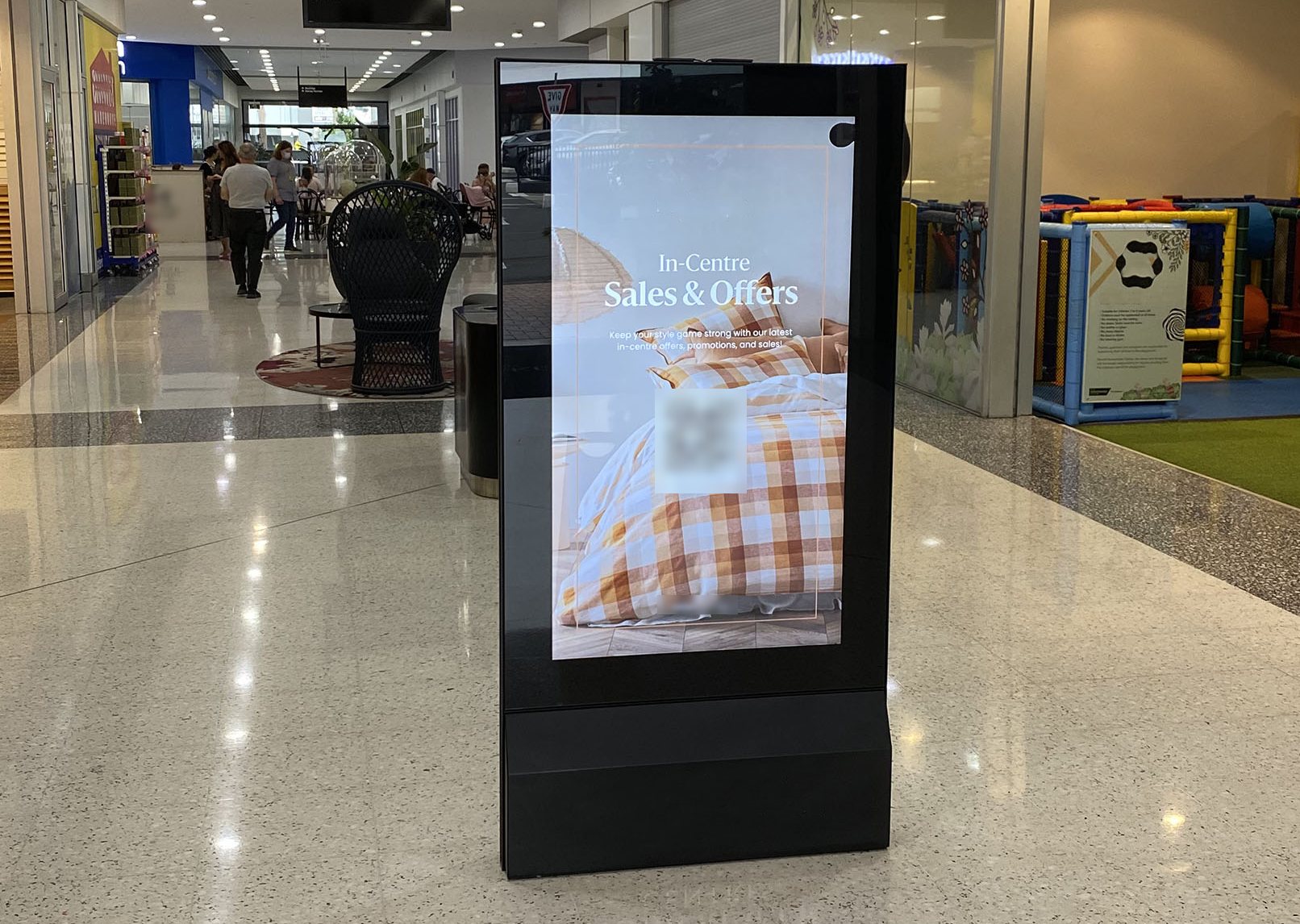 Freestanding digital advertising screen in a shopping centre mall