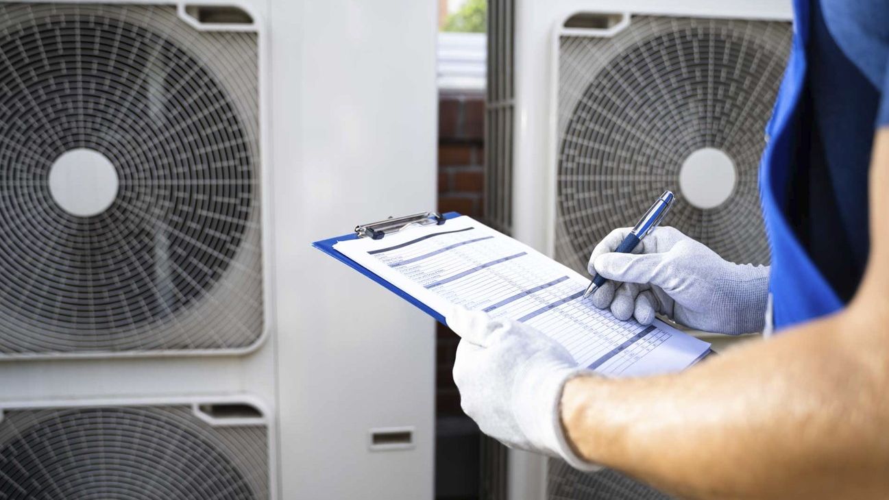 Technician logging a service at rooftop air conditioning units