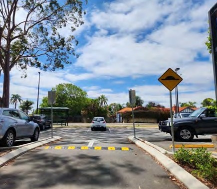 A speed hump sign at a car park entry lane