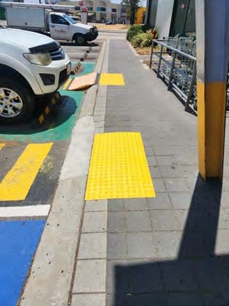 Warning tactiles on a footpath beside the parking bays