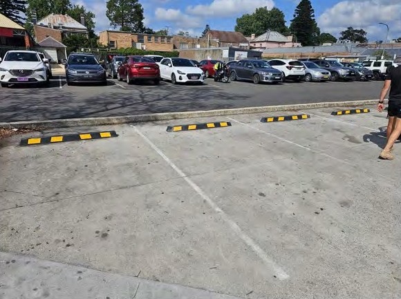 Yellow and black wheel stops across a row of bays